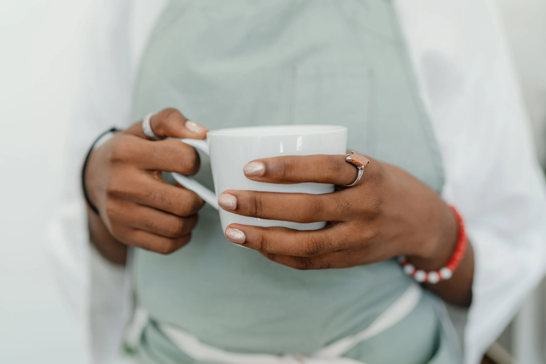 Photographie en gros plan d’une personne en tablier tenant une tasse de café